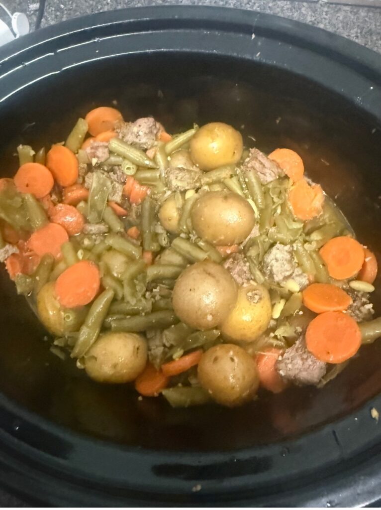 Finished slow cooker garlic butter steak bites with baby potatoes, carrots, and green beans