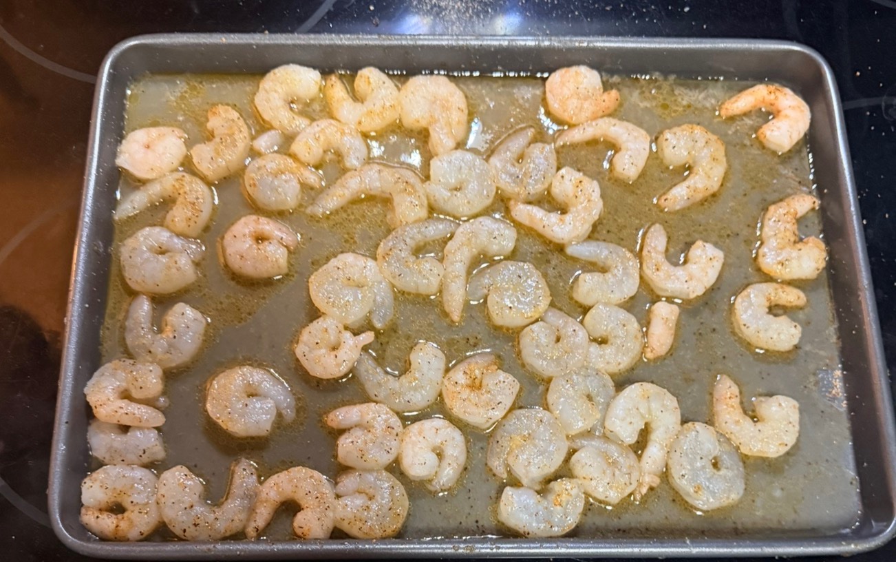 Seasoned shrimp laid out on a sheet pan